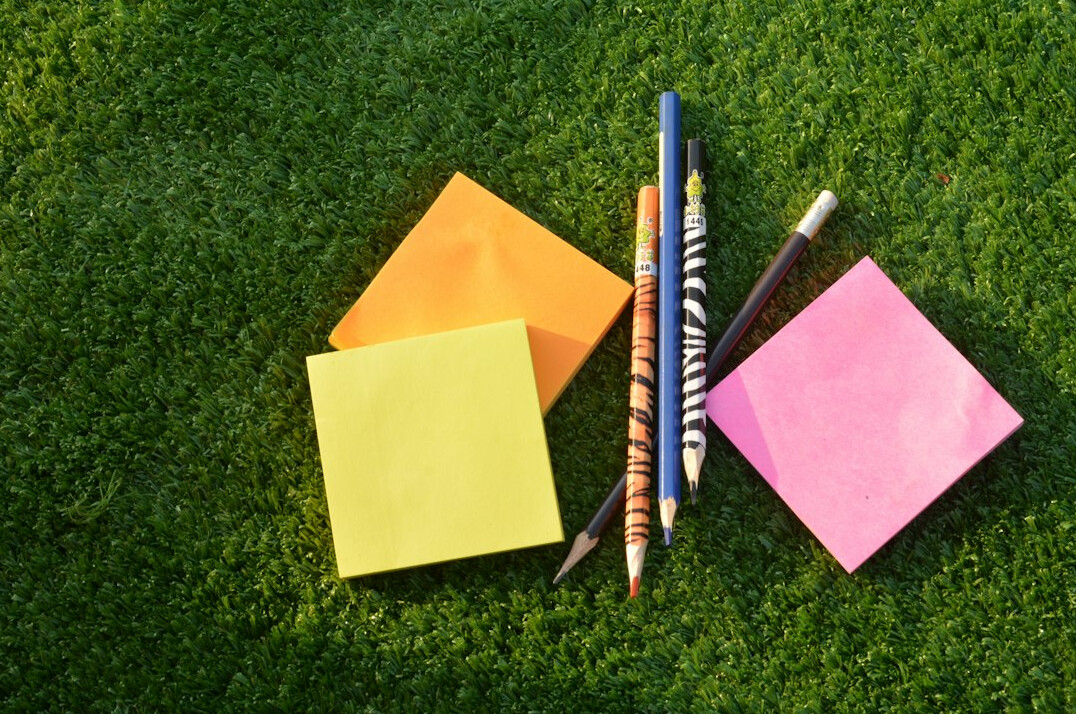 Notes and sticky papers planned on a desk with a pen